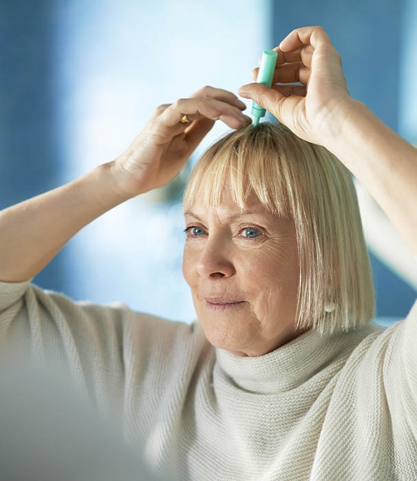 senior woman checking hairline for hair loss | Hair rejuvenation jefferson city MO