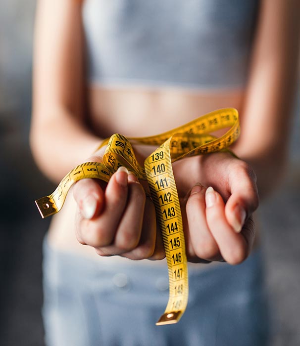 Skinny female hands are tied with measuring tape. Fat or calories burning concept. Weight loss